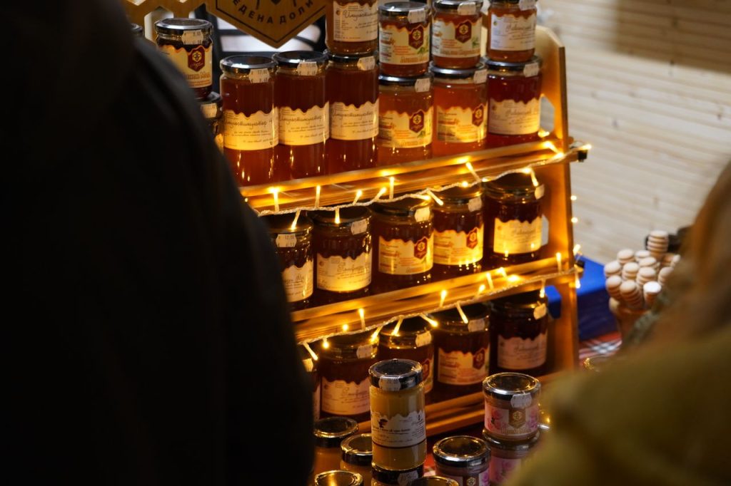 Crafting Captivating Headlines: Your awesome post title goes here A cozy display of various honey jars lit with warm fairy lights at a market.